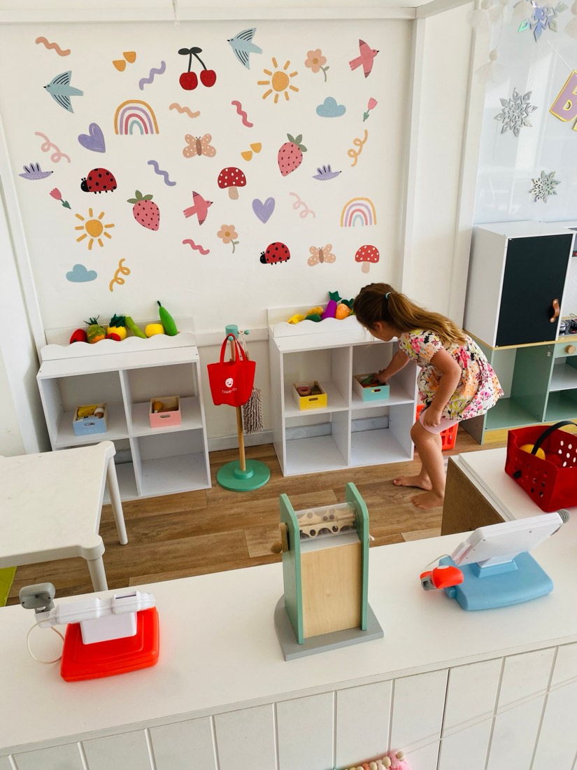 Girl choosing play food in the studio's pretend shop