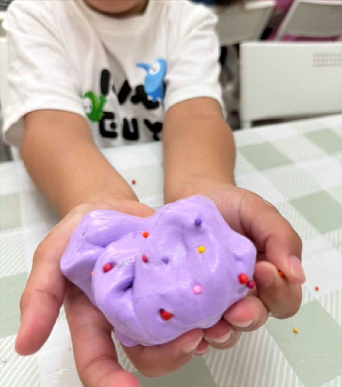 Child holding colourful slime at a B.Curious slime party