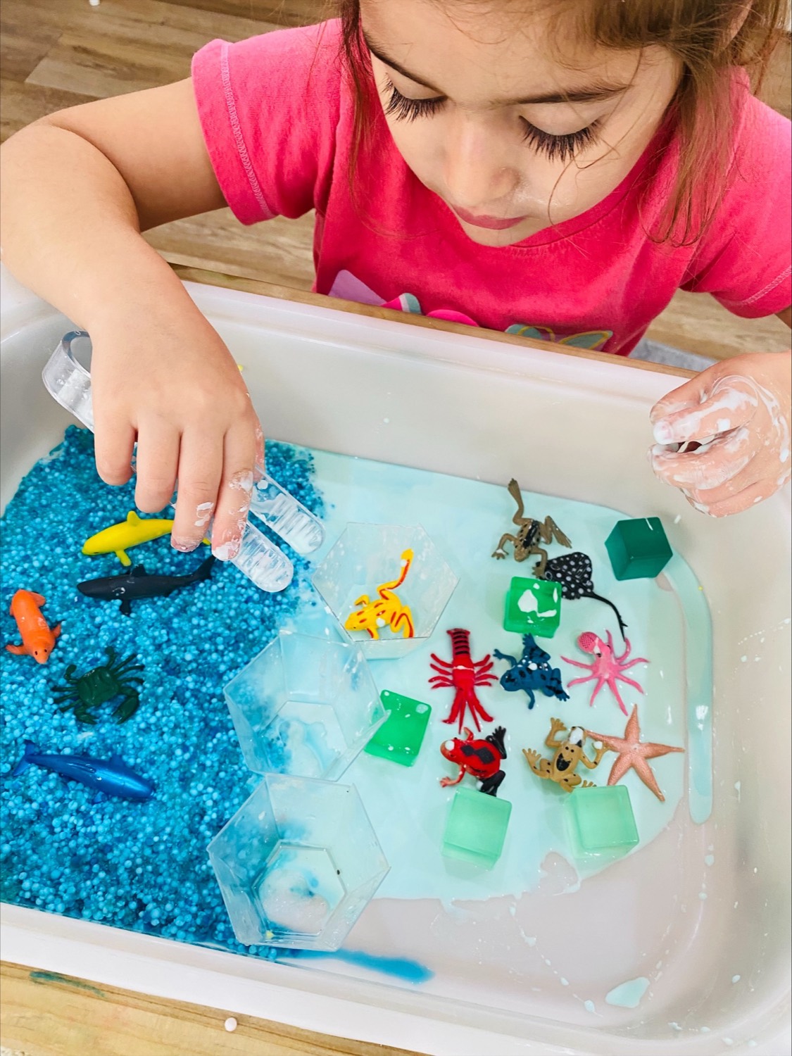 Child exploring a calm water bead sensory tray at B.Curious