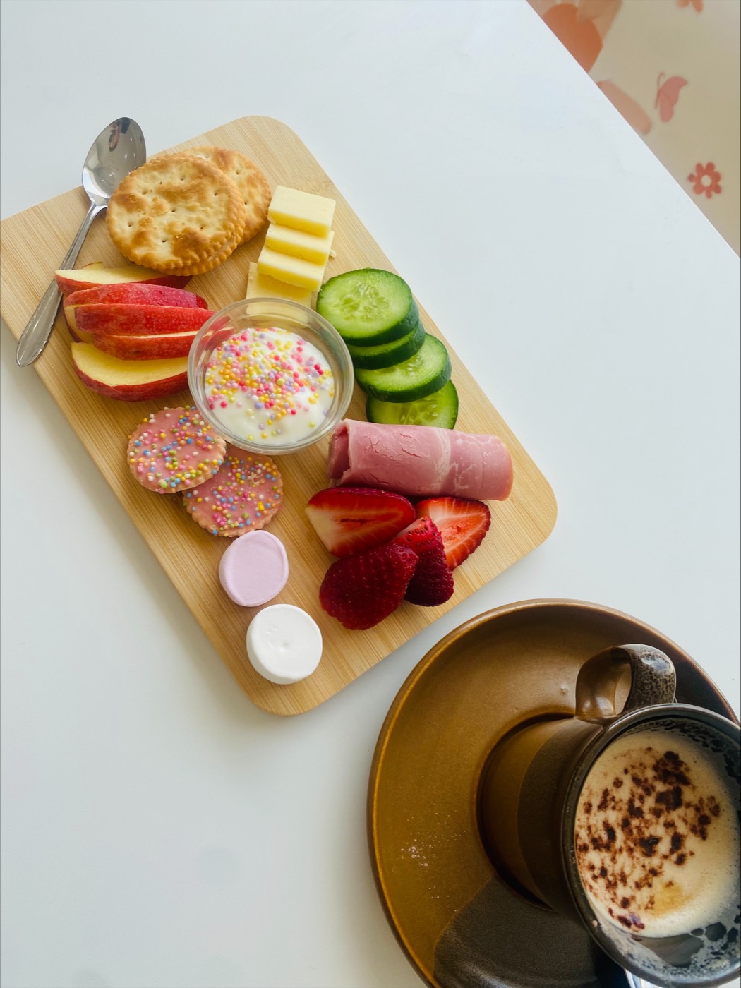 A hot coffee and a fresh snack plate