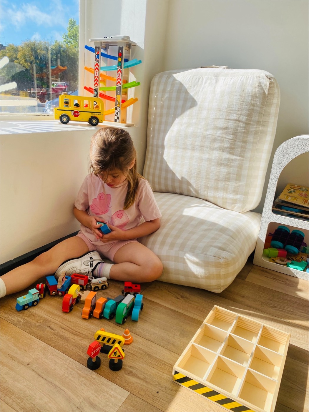 Child playing with toy trains by the window